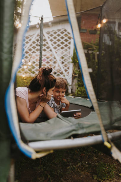 istock Mother and son on a trampoline, using digital tablet 1186594511