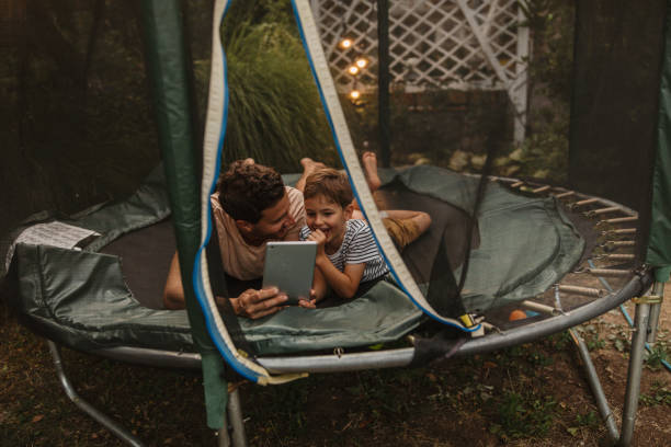 istock Watching cartoons together, while lying on a trampoline 1186594518
