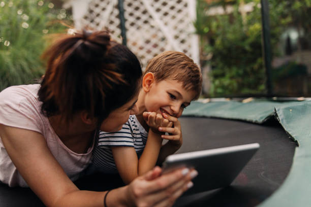istock Mother and son on a trampoline, using digital tablet 1186594519