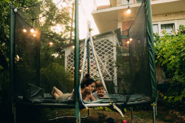 Mother and son on a trampoline, using digital tablet