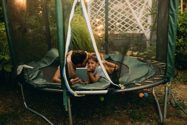 istock Watching cartoons together, while lying on a trampoline 1186595215