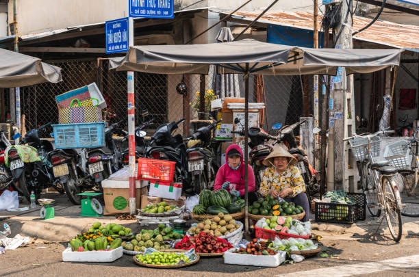 두 명의 여성이 베트남 나트랑(nha trang) 코너에서 갓 수확한 과일을 판매합니다. - lime market vietnam fruit 뉴스 사진 이미지