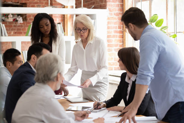 istock Diverse team and aged boss do paperwork analyzing financial report 1186603918