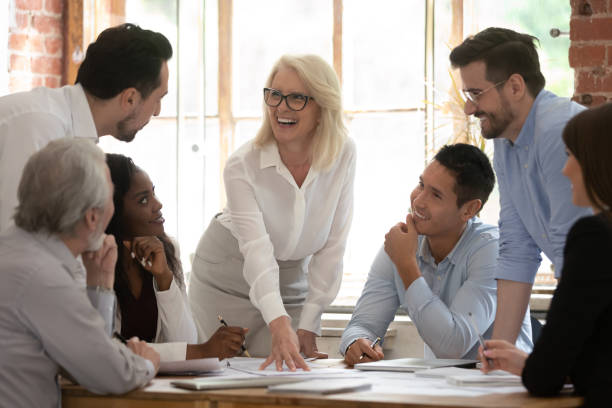 istock Middle aged boss and company staff discuss project at meeting 1186603939