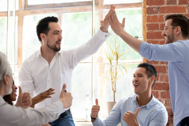 istock Diverse business partners giving high five celebrating successful work 1186603942
