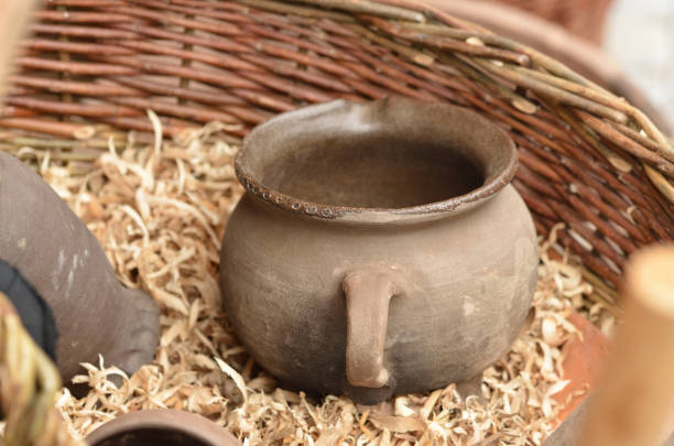 istock Old medieval ceramic jug lying in a wicker basket with shavings 1186604002
