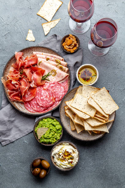 istock Antipasto. Meat platter, chips and sauces, red wine on gray background. Top view 1186604757