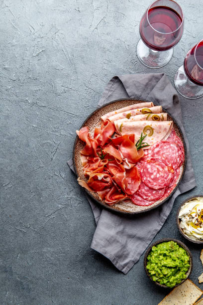 istock Antipasto. Meat platter, chips and sauces, red wine on gray background. Top view 1186604776