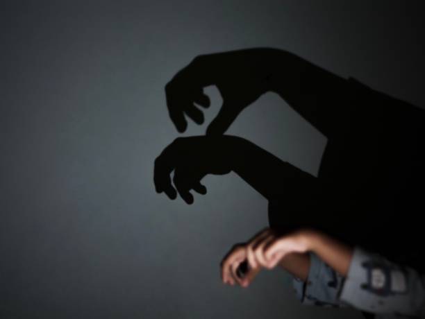istock Asian young kid playing shadow on the wall 1186609734