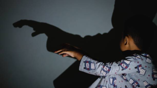 istock Asian young kid playing shadow on the wall 1186609762
