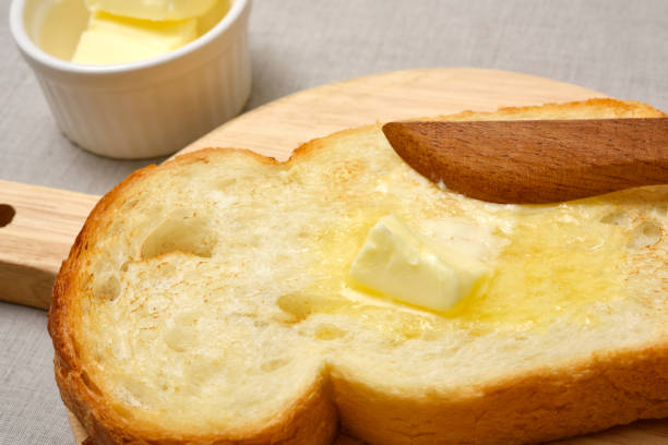 istock Bread with butter on wooden board 1186615225