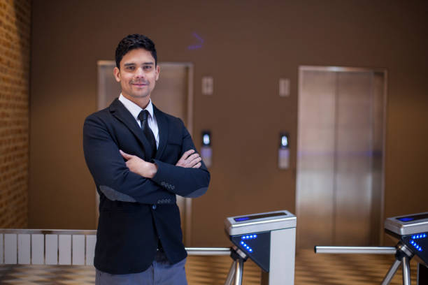 Portrait of a businessman at the office entrance Portrait of a Latin ethnic business man aged 25-35 years arriving at work and is at the office entrance latin script stock pictures, royalty-free photos & images