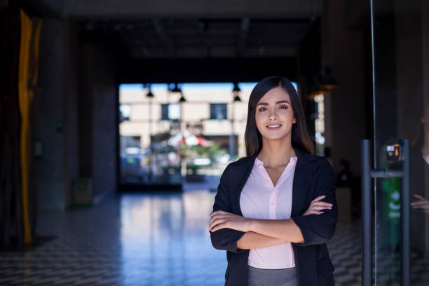 Portrait of a business woman arriving at the office Portrait of a woman of Latin ethnicity aged 20-30 years arriving at work and entering the office entrance latin script stock pictures, royalty-free photos & images