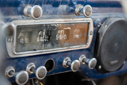 Dashboard at front of abandoned vintage truck with ammeter, oil indicator, various knobs