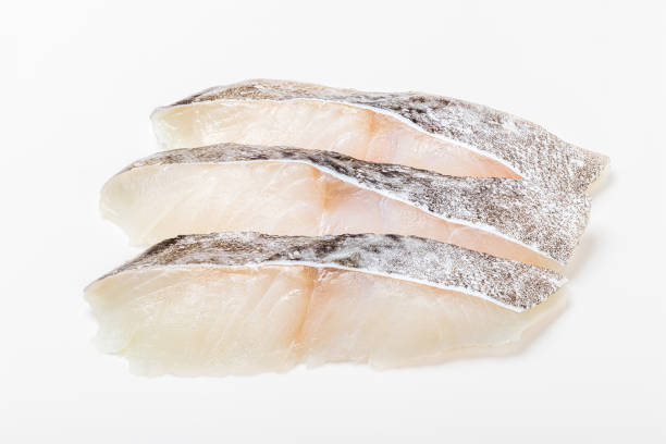 филе трески на белом фоне - cod fillet raw prepared fish стоковые фото и изображения
