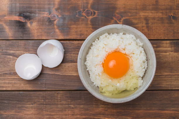 istock A raw egg over rice  on wood grain background 1186623892