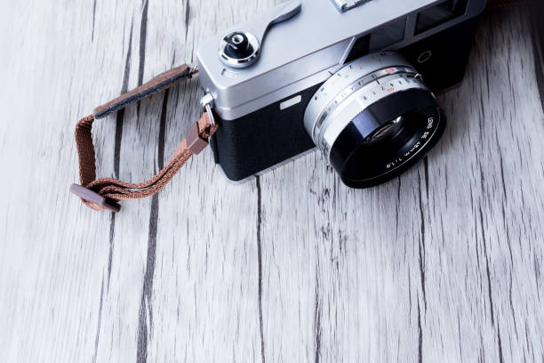 istock Silver camera on old wooden background 1186625433