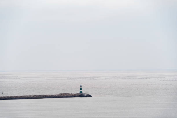 lighthouse and groyne on sea