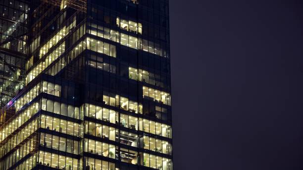 istock Pattern of office buildings windows illuminated at night. 1186646899