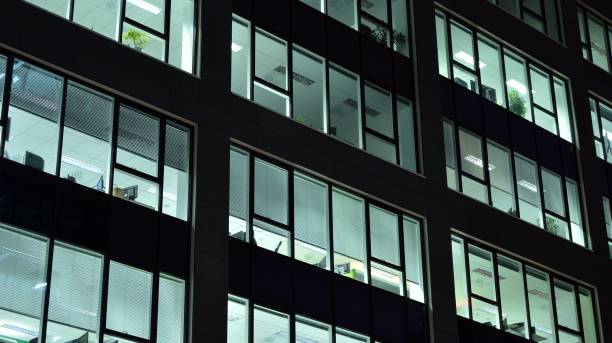 istock Pattern of office buildings windows illuminated at night. 1186646919
