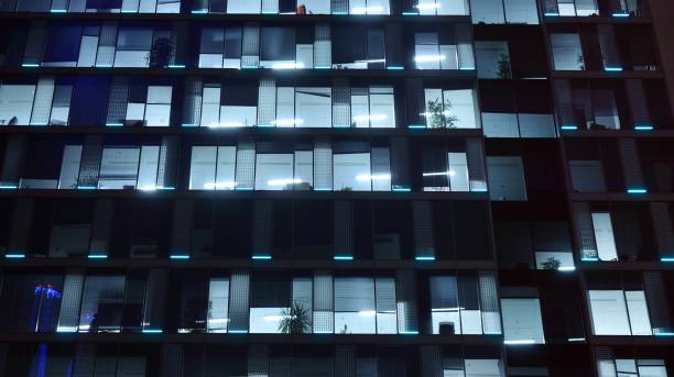 istock Pattern of office buildings windows illuminated at night. 1186646987