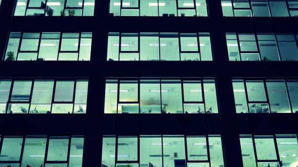 istock Pattern of office buildings windows illuminated at night. 1186647093
