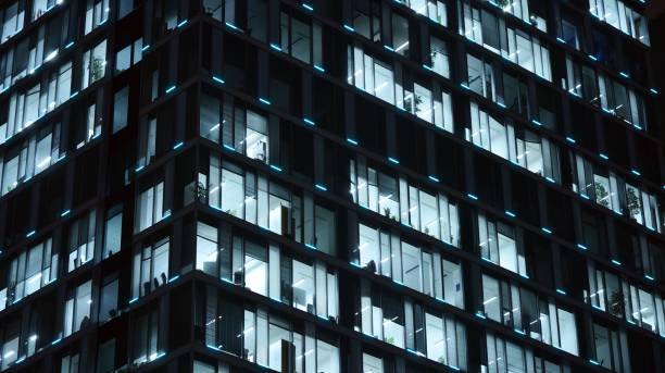istock Pattern of office buildings windows illuminated at night. 1186647709
