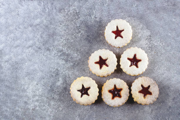 nouvel an 202 arbre. biscuits de linzer de noel avec la confiture rouge de baie sur le fond gris de table en béton. vue du haut, plat laïc - cookie christmas shortbread christmas tree photos et images de collection