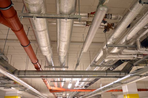 istock Water pipes and cable trays run under ceiling of a building 1186654992