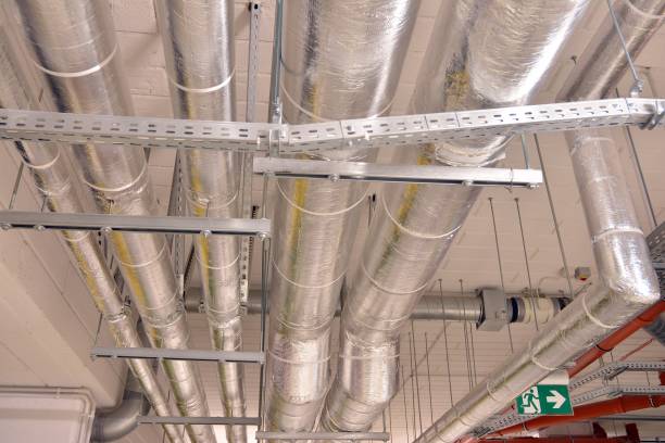 istock Water pipes and cable trays run under ceiling of a building 1186655248