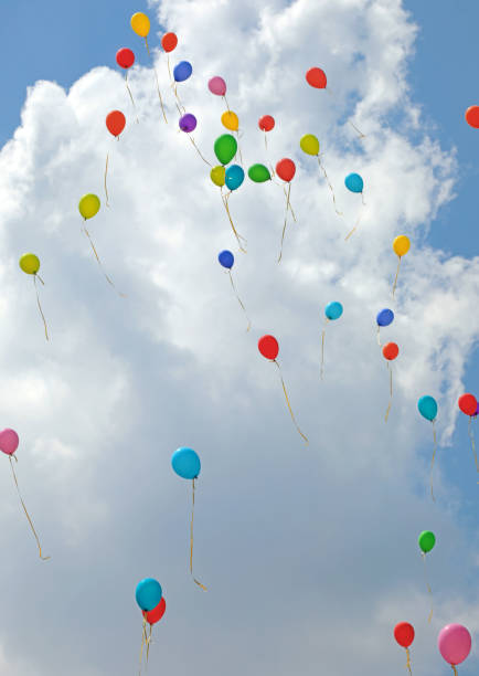 many colored balloons fly up towards the sky