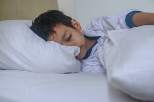 Asian boy sleeping on the bed