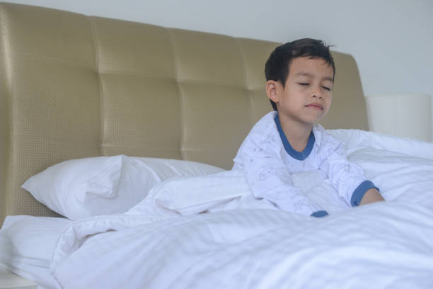 istock Asian boy waking up in the morning 1186658583