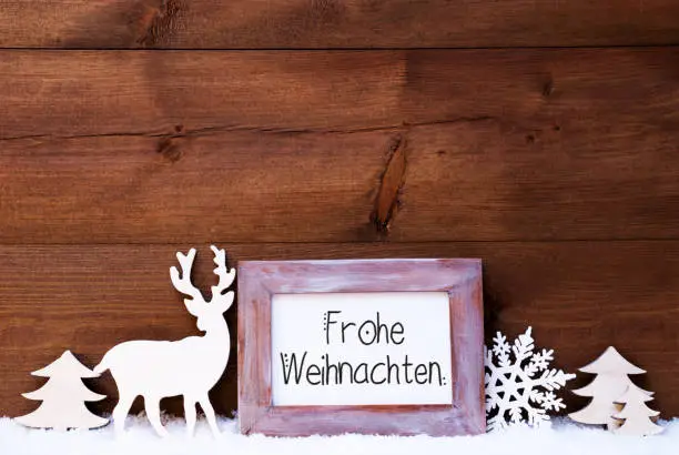 Vintage Frame With German Calligraphy Frohe Weihnachten Means Merry Christmas. Christmas Decoration Like Deer And Tree. Wooden Background With Snow