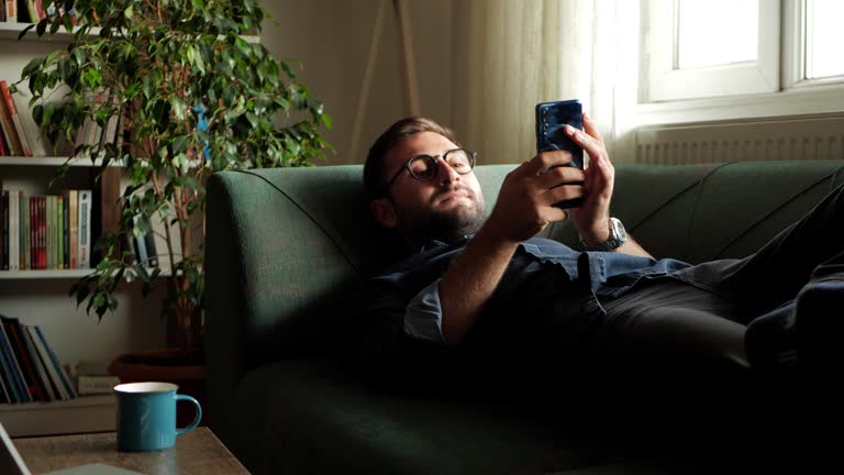 Young man using mobile phone at home