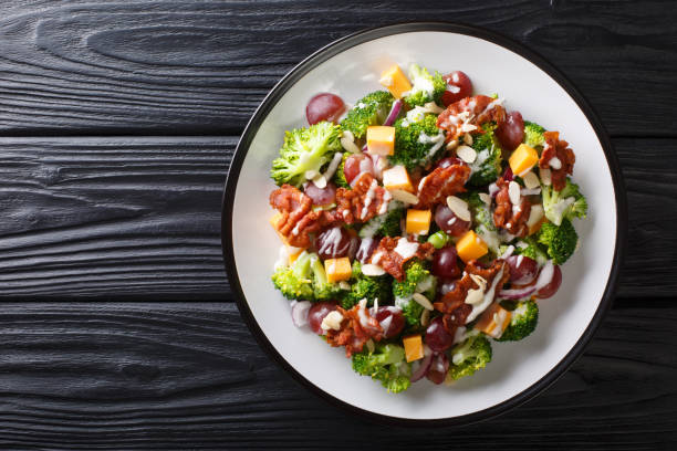 salada do feriado com bróculos, queijo, uvas, bacon, amêndoas e cebolas close-up em uma placa. vista superior horizontal - italian salad - fotografias e filmes do acervo