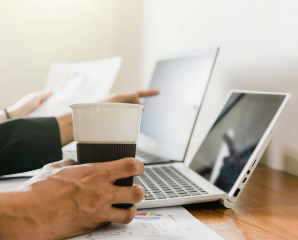 istock The hand that holds the coffee cup on the desk 1186661646