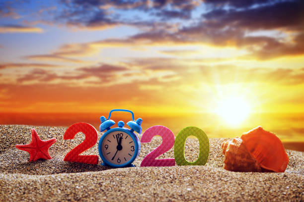 istock Number 2020, alarm clock and sea shell on the beach. 1186664950