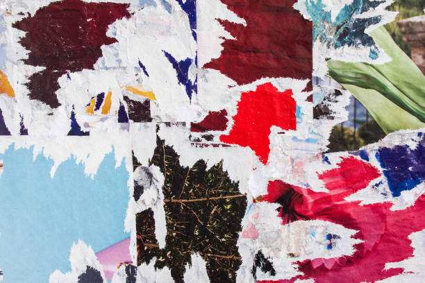 istock Old colourful torn and peeling poster paper on dirty billboard background. 1186665785