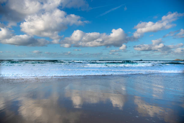 Reflections in wet and of cloudscape on a seascape in November