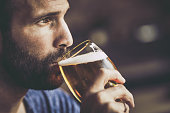 Close up of pensive mid adult man drinking beer in a pub.
