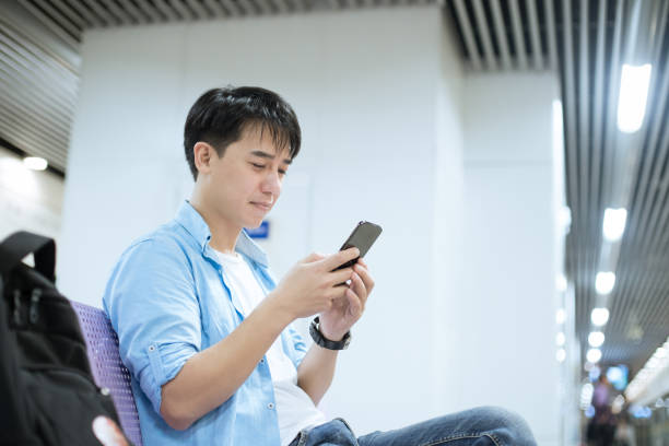 istock young asian man using mobile phone at railway station 1186673055