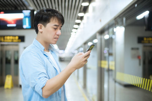 istock young asian man using mobile phone at railway station 1186673135