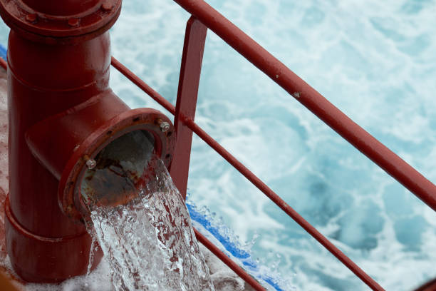 View of Ballast Water exchange process onboard of a ship using flow-through method underway in open ocean. Overflow method through ballast tank air head. View of ballast water exchange process onboard of a ship using flow-through method underway in open ocean. Overflow method through ballast tank air head. Ballast Water exchange Management and Treatment concept. ballast water stock pictures, royalty-free photos & images