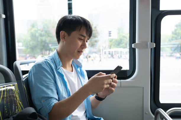 istock young asian man using smart phone on bus 1186673694