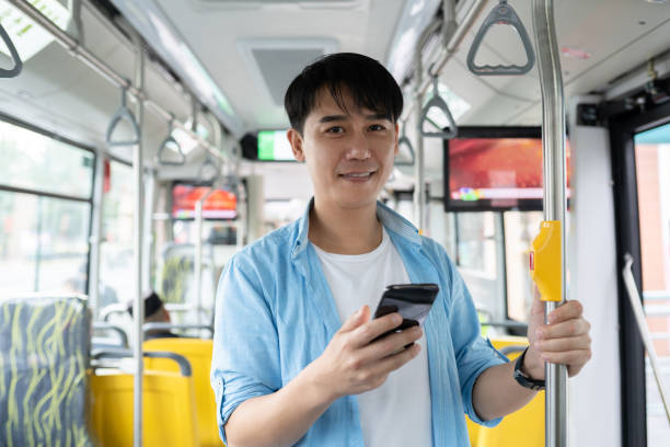 istock young asian man using smart phone on bus 1186673726