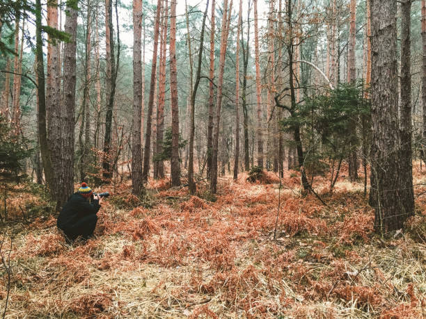 Male hiker taking photo in forest in winter. hoto taken on mobile device, iPhone 6s