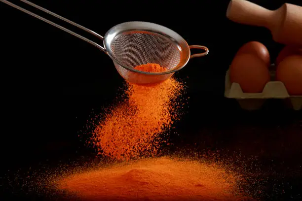 A Sieve finely grading flour and food colouring to prepare meal