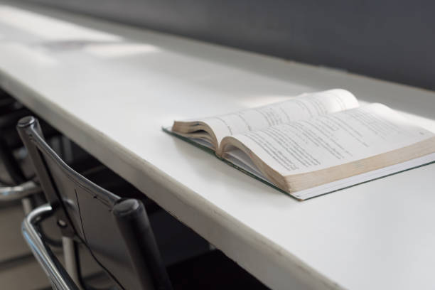 istock Opened book place on the table in public library. 1186686504