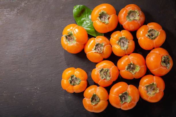 istock ripe persimmon fruit on a dark background, top view 1186686686